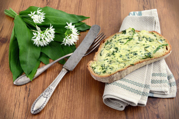 breakfast with dark bread and wild garlic butter. fresh bunch of ramson on background. stock photo