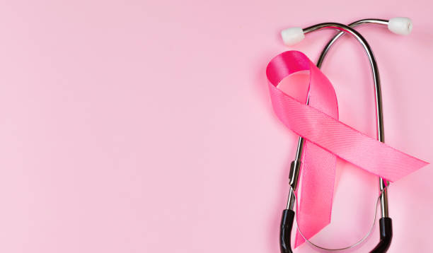 Breast Cancer Awareness Month. Pink ribbon and stethoscope on colored background. Women's health care concept. Symbol of fight against oncology. stock photo