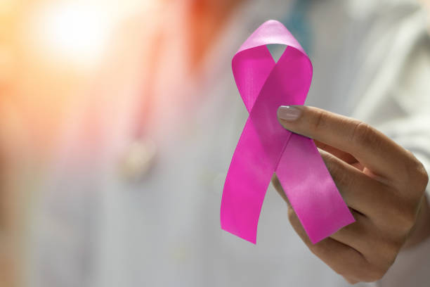 кампания рака молочной железы с женщиной-врачом провести розовую ленту осведомленности для выживших. медицинское здравоохранение фон кон� - breast cancer стоковые фото и изображения