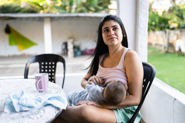 breastfeeding in the backyard stock photo