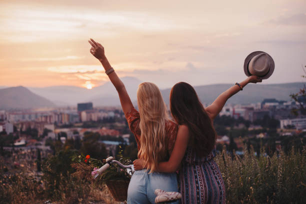 Breath the life Two awesome girls cheering life in front of the sunset boho photos stock pictures, royalty-free photos & images