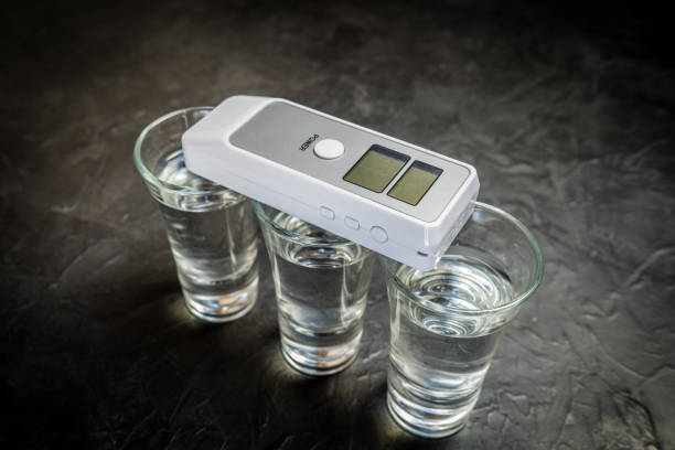 breathalyzer and alcohol in a glass. photo on a dark background. breathalyzer and alcohol in a glass. photo on a dark background. breathalyzer and alcohol in a glass. photo on a dark background. bar drink establishment photos stock pictures, royalty-free photos & images