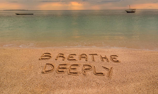 Breathe Deeply In the photo a beach in Zanzibar at sunset where there is an inscription on the sand "Breathe Deeeply". deep stock pictures, royalty-free photos & images