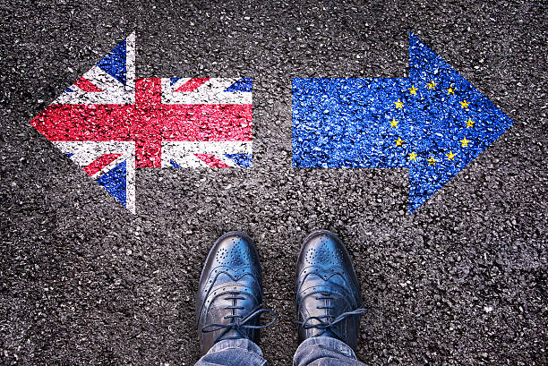Brexit, flags of the United Kingdom and the European Union Brexit, flags of the United Kingdom and the European Union on asphalt road with legs brexit stock pictures, royalty-free photos & images