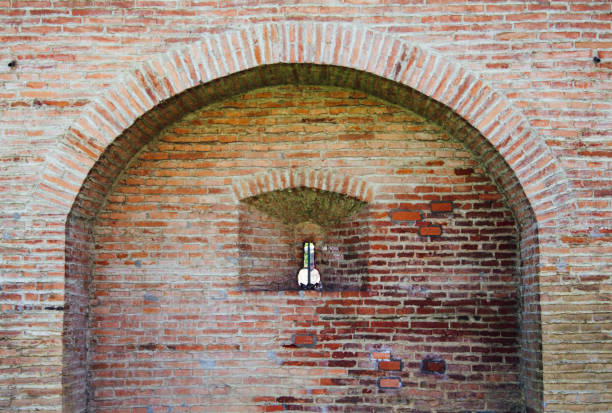Brick arch on old citadel wall with a keyhole like shape window, Targu Mures Romania stock photo