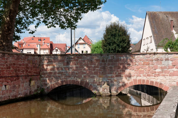 Brick bridge with reflection in canal of Wissembourg, France canal in Wissembourg, with reflection of bridge bas rhin stock pictures, royalty-free photos & images