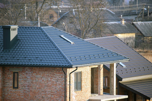 Brick house with roof top covered with metallic shingles. Tiled covering of building under construction stock photo