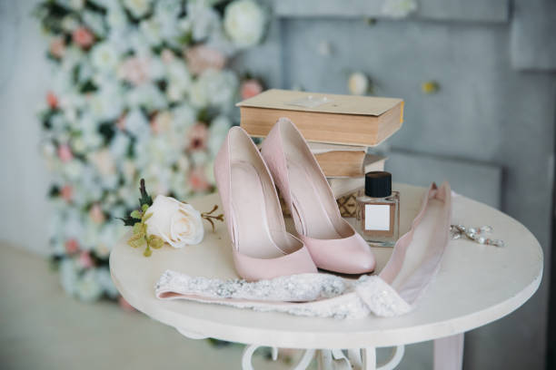 Bridal accessories on a white chair with flowers, perfume shoes. Clothing concept stock photo
