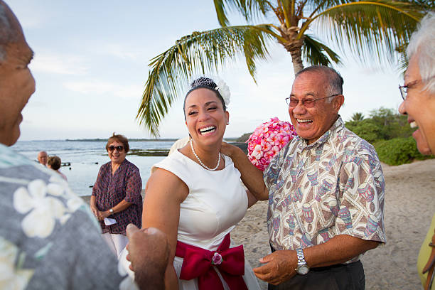Bridal Laughter Hawaiian beach bride laughing it up with friends and family after the ceremony. neicebird stock pictures, royalty-free photos & images