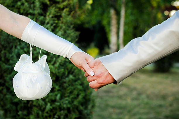 Bride and groom holding hands stock photo