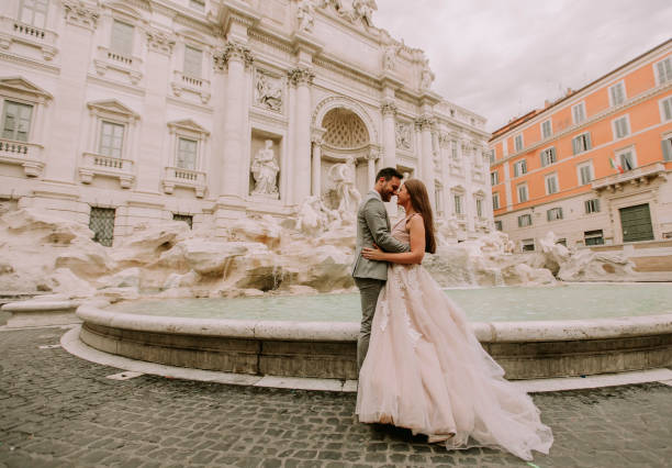 Bride and groom posing in front of Trevi Fountain (Fontana di Trevi), Rome, Italy stock photo