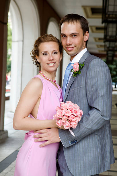 bride and groom standing at building stock photo