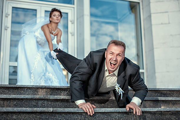 Bride dragging groom at the wedding. Bride leg pulls groom at the wedding. approaching photos stock pictures, royalty-free photos & images