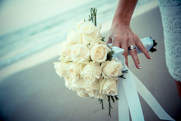 Bride hands on yellow flowers stock photo