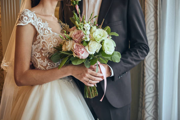 Bride holding a wedding bouquet in the hands standing near groom Bride holding a wedding bouquet in the hands standing near groom wedding ceremony stock pictures, royalty-free photos & images