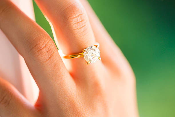 Bride Wearing Diamond Ring Close-up Of A Bride's Hand With Diamond Ring gold ring on finger stock pictures, royalty-free photos & images