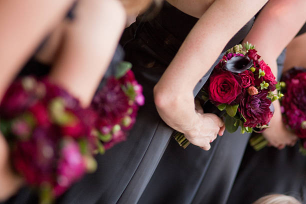 Bridesmaids in gray dresses with fuschia colored bouquets stock photo