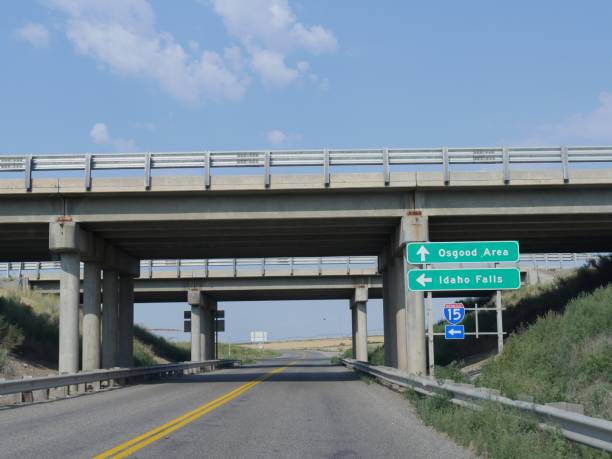Bridges over the road with signs on the road leading to directions to Osgood Area and Idaho Falls, Idaho. stock photo