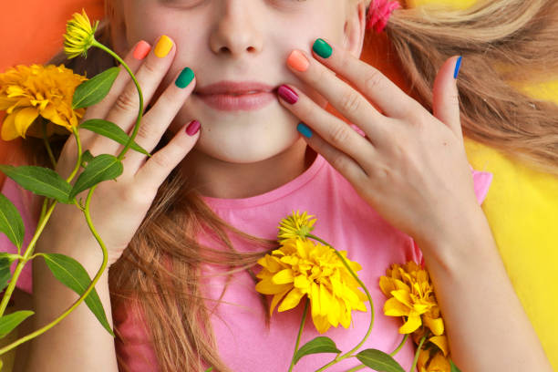Bright and colorful children's manicure on the nails of girls stock photo