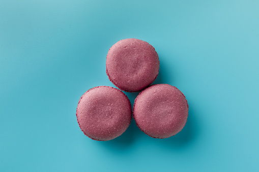 Bright food photography of macaroons on blue background. Top view