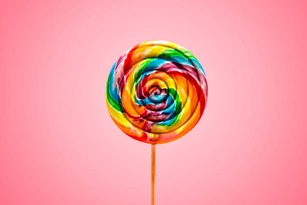 Bright Fun Colorful Swirl Lollipop on Pink Background stock photo