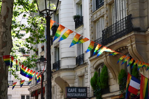 Bright garlands of striped triangle banners in colors of LGBTQ flag on street of Paris France stock photo