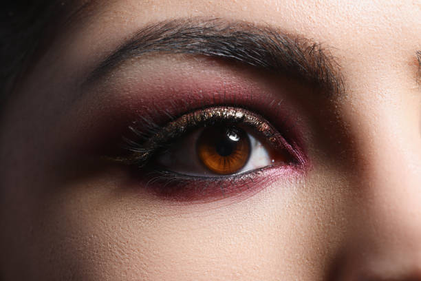 Bright pink professional makeup on eyes of woman closeup stock photo