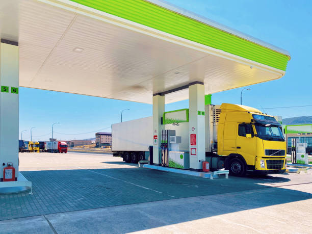 bright yellow truck with refrigerated semi-trailer at the fuel stop for refueling stock photo