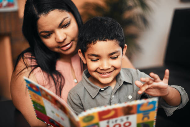 brightening his world with books - child reading imagens e fotografias de stock
