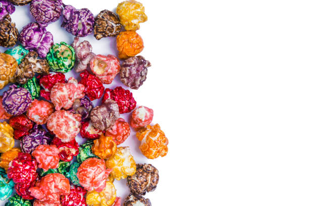 Brightly Colored Candied Popcorn, white background. Horizontal image of Junk food, fruit flavored popcorn. Colorful, rainbow, candy coated popcorn. Shallow focus on popcorn in bowl. Isolated on white selective focus and copyspace. stock photo