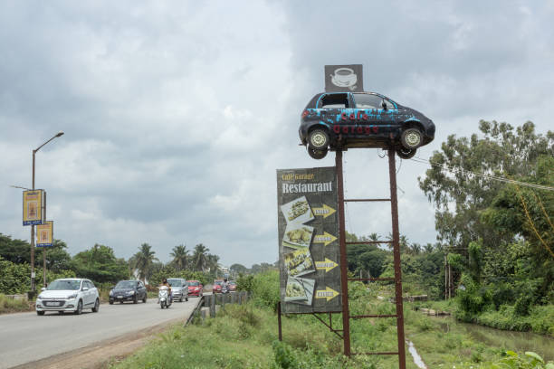 A Brilliant Advertising idea of a Restaurant in Car Theme near Mysore/Karnataka. An Innovative Advertising strategy by placing a Car on a High point in front of a Highway Cafe near Mysore in Karnataka state of India. mysore stock pictures, royalty-free photos & images