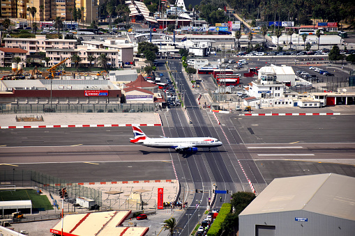 Gibraltar city, Gibraltar - august 21, 2017: british airways airplane go along the gibraltar airport runways with a crossing street