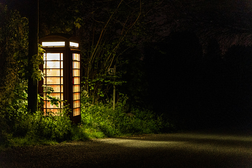 British telephone box at night in remote Welsh country lane