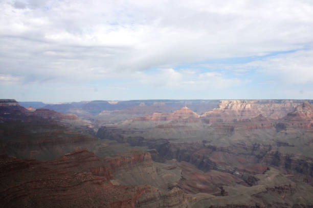 Broad Landscape of the Grand Canyon Under Cloudy Sky and Shadow in the Foreground stock photo