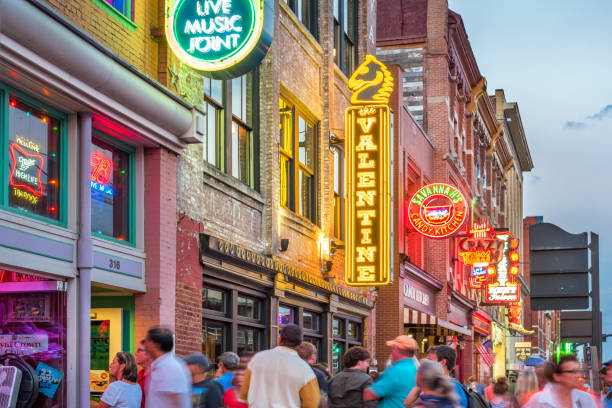 Broadway pub district in downtown Nashville Tennessee USA People enjoy a pleasant evening in the Broadway pub district, downtown Nashville, Tennessee, USA at twilight. broadway nashville stock pictures, royalty-free photos & images