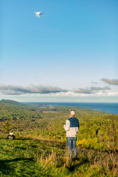 Brockway Mountain Drive Michigan, USA - October 4, 2017: A tourist is playing a drone on the peak of Brockway Mountain in Copper Harbor of Michigan,USA. michigan shooting stock pictures, royalty-free photos & images