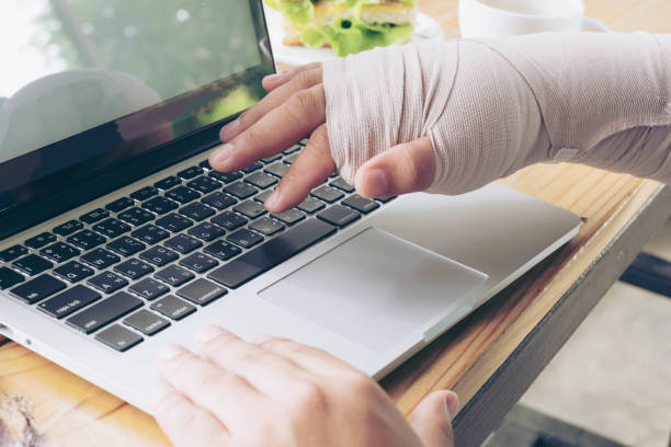 Broken Arm Man Using Laptop Computer, Accident and Insurance Concept stock photo