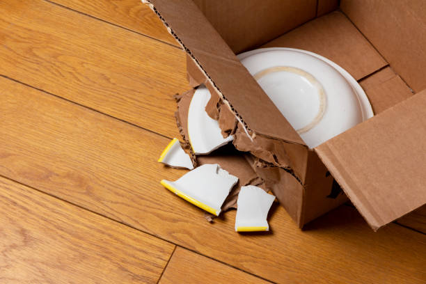 broken ceramic plate in a cardboard box stock photo