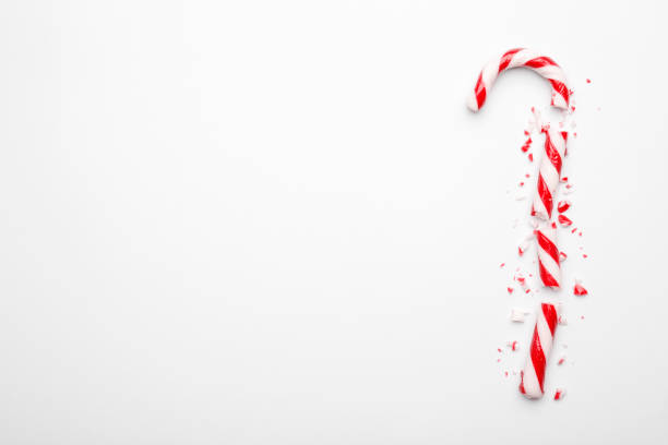 Broken Christmas candy canes on white background. Minimal composition with peppermint candies. Flat lay, top view with space for text  candy canes stock pictures, royalty-free photos & images