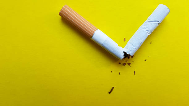 노란색 배경에 고립 된 깨진 담배. 위에서 보기 - 니코틴 뉴스 사진 이미지