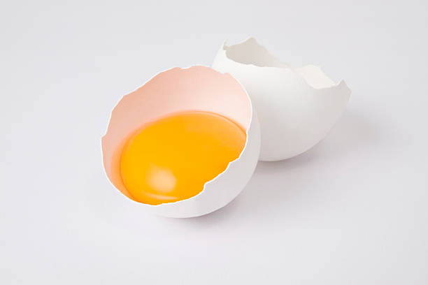 Broken Egg Cracked egg isolated on white background. egg yolk stock pictures, royalty-free photos & images