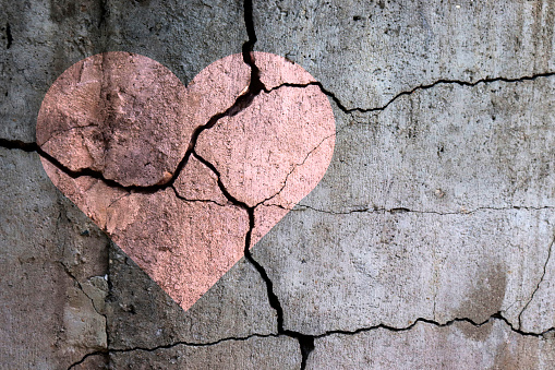 A broken heart. Drawing of a heart on a cracked wall. Broken relationships. Treason and betrayal. Past love. A quarrel.