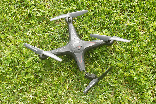 Broken quadcopter on grass stock photo