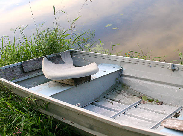 broken rowboat on a pond stock photo