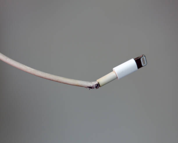 broken smartphone's charger cable stock photo