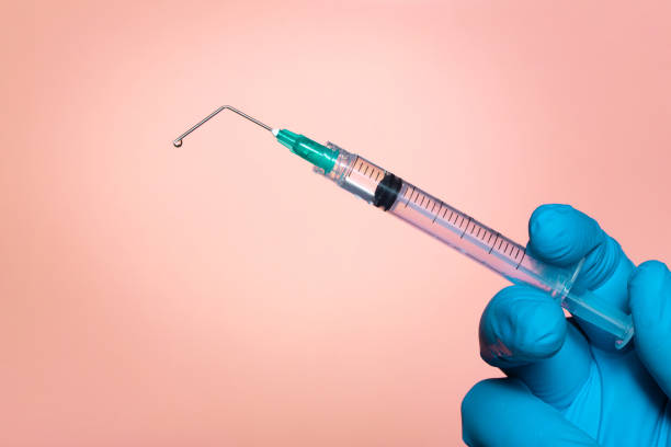 Broken vaccine syringe needle, vaccination or anti-vaccination concept, on pink background stock photo