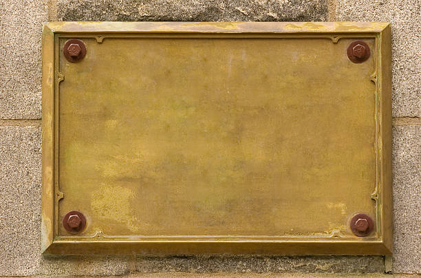 Bronze empty plaque fixed on wall Bronze plaque on the wall. bronze alloy stock pictures, royalty-free photos & images