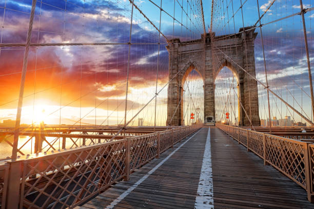 Brooklyn Bridge over East River viewed from New York City Lower Manhattan waterfront at sunset.  brooklyn bridge stock pictures, royalty-free photos & images