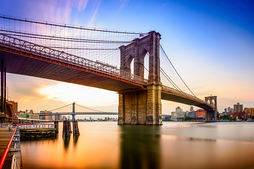 New York City, USA at the Brooklyn Bridge and East River at dawn.