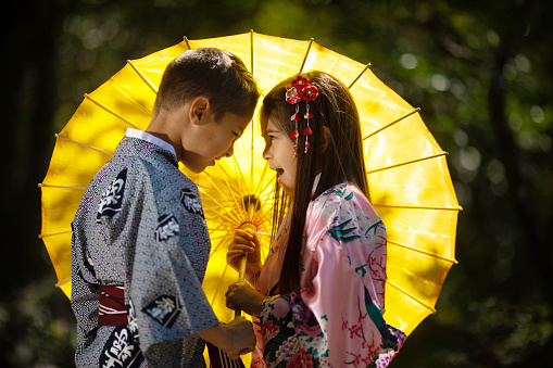 Brother and sister with yellow umbrella